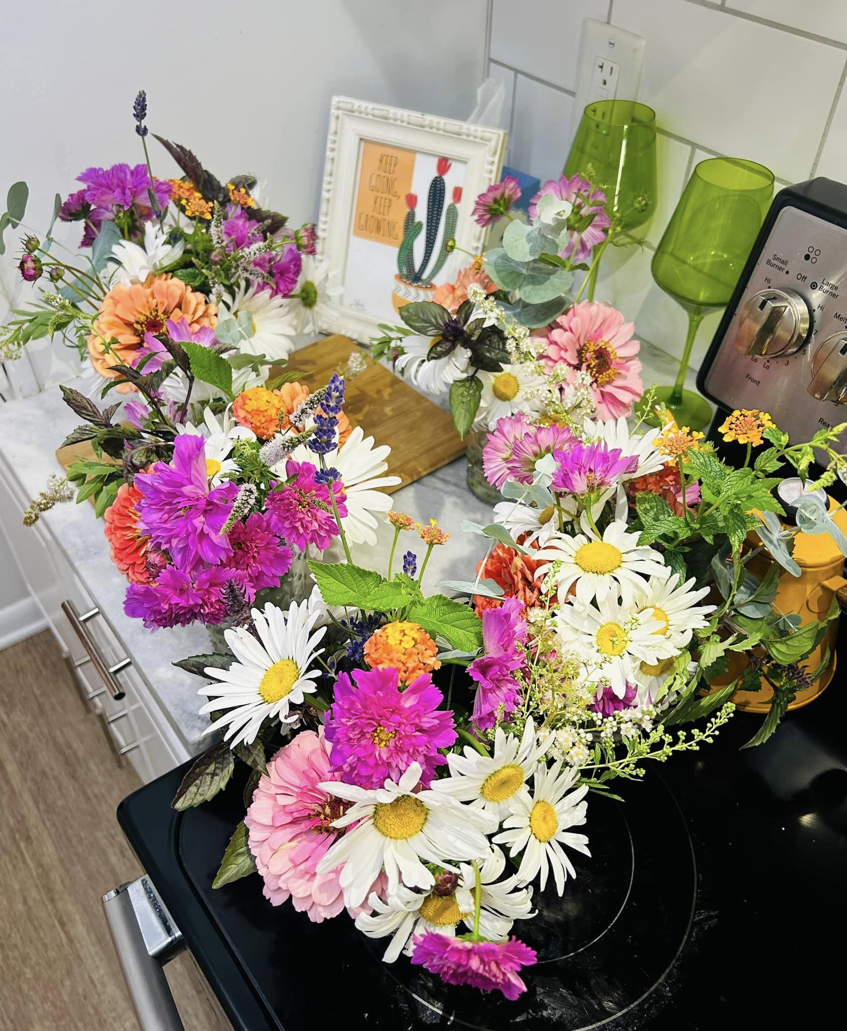 multiple bouquets in pinks orange and white arranged on a kitchen counter