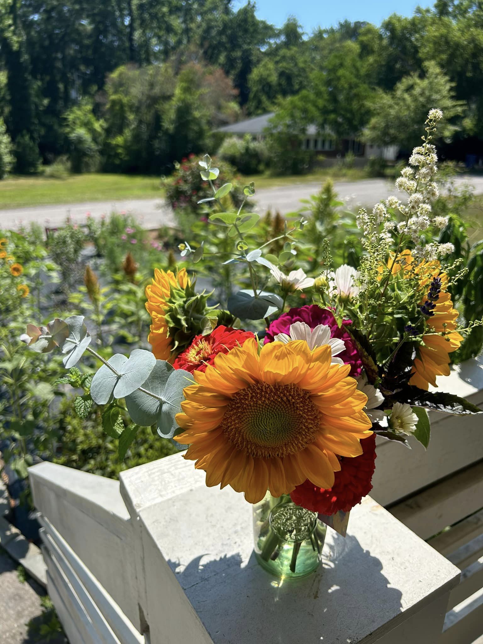 magenta zinnia and assorted flowers in a cut glass vase