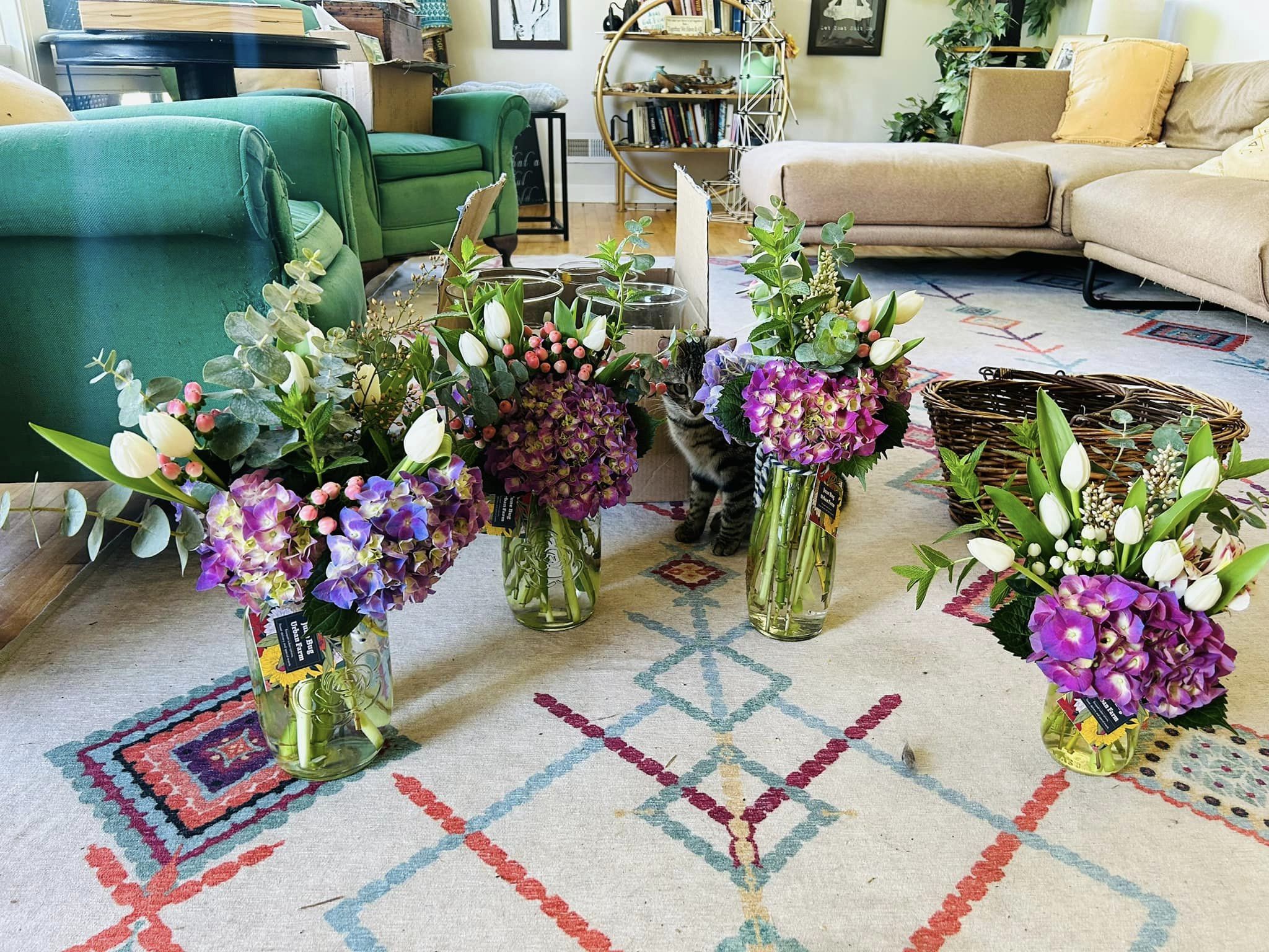 large floral arrangments in glass vases on the floor of a living room